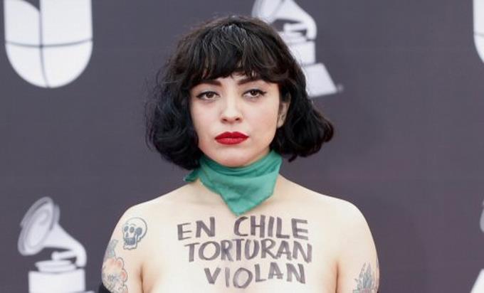 Mon Laferte desnuda su torso en Latin Grammy y denuncia que en Chile “matan”